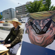 A South Korean protester sits next to a poster with an illustration of U.S. President Donald Trump to oppose a plan to deploy an advanced U.S. missile defense system called Terminal High-Altitude Area Defense, or THAAD, near the U.S. Embassy in Seoul on Monday, June 5, 2017 (AP Photo/Ahn Young-joon)